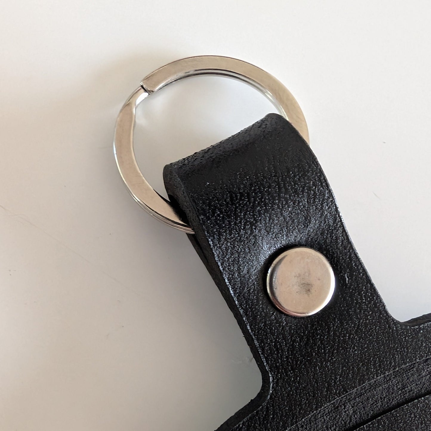 Black leather key fob with metal ring and button